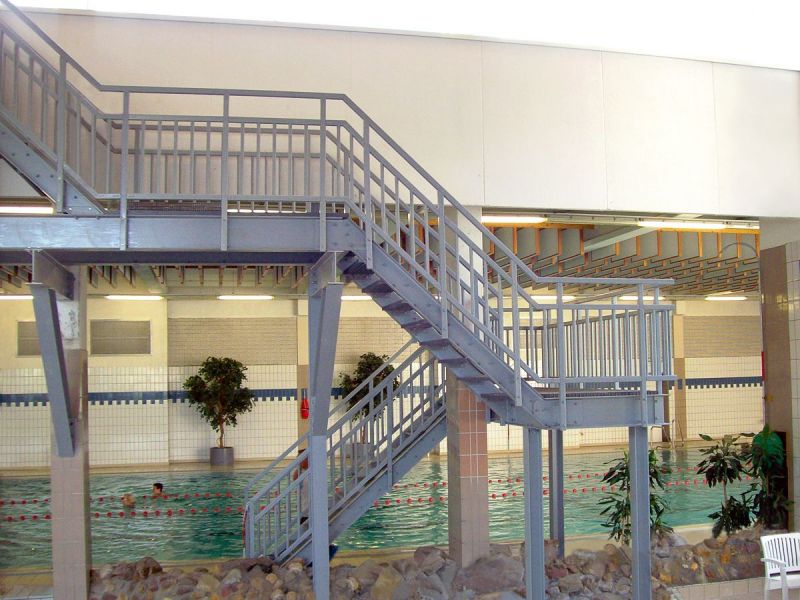 GFK Treppe von Fibrolux in Schwimmbadumgebung, mit Handlauf und Podest, sicher begehbar, rutschfest und chemikalienresistent